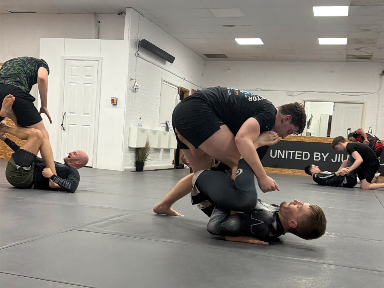 Two4 members working through live grappling rounds in the training room