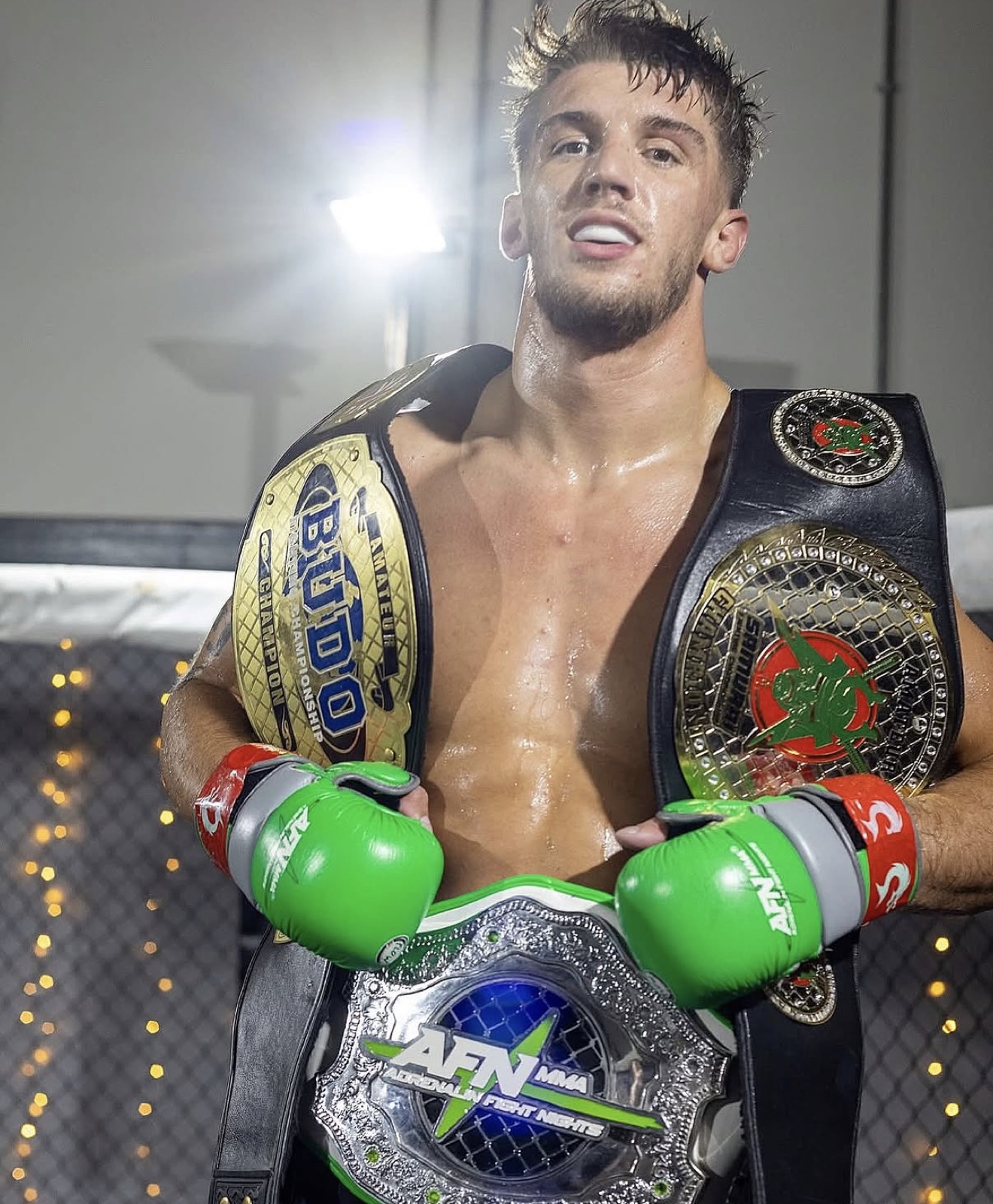 MMA athlete Cam Brown wearing three amateur title belts